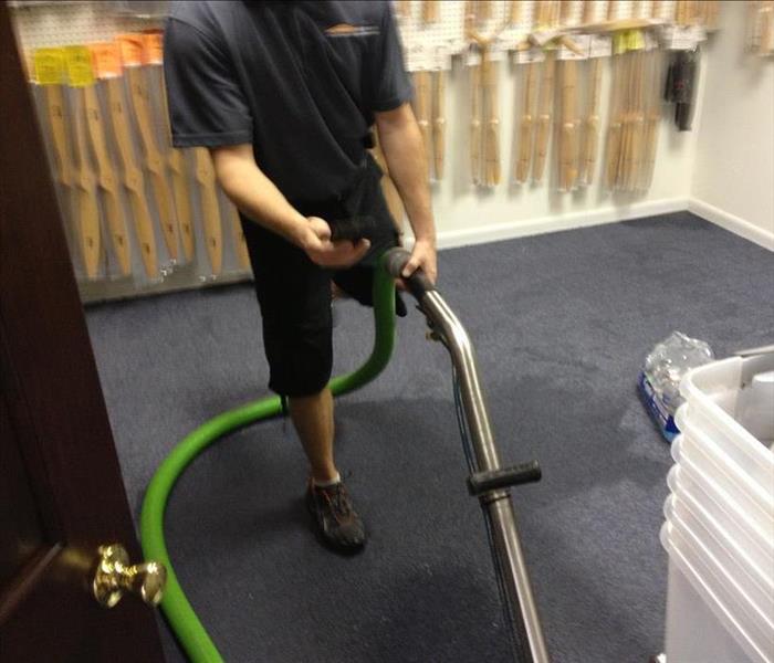SERVPRO technician extracting water from the carpet of a Lakeland business