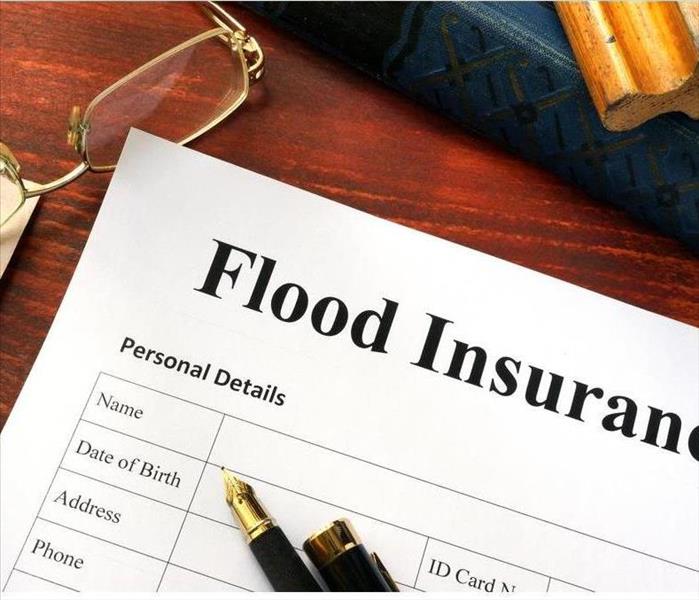 Flood insurance form on a table with a book.