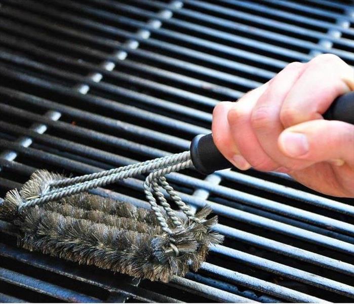 Cleaning a grill at a summer barbecue party.